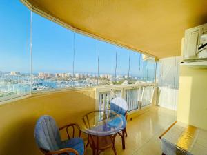 a balcony with a table and chairs and a large window at La Manga apartamento Siesta in San Blas