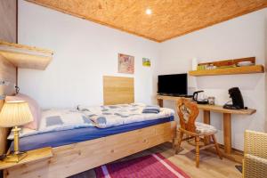 a bedroom with a bed and a desk and a chair at Einzimmerwohnung im Haupthaus in Ruhland
