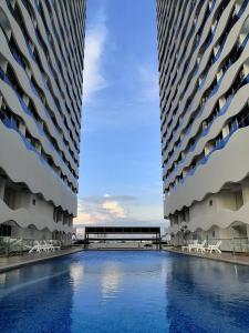 馬六甲的住宿－The Wave Residence Melaka Kota Laksamana，两栋高大的建筑,中间设有游泳池