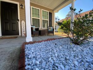 een huis met een rotstuin op de veranda bij Cozy and Luxury Home in Raleigh