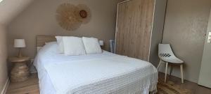 a bedroom with a white bed and a white chair at Cocon sous les toits - vue sur les châteaux et le vignoble - proche centre ville - parking gratuit in Sélestat