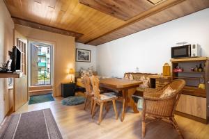 Ruhland的住宿－Obere Ferienwohnung im Nebengebäude，一间带木桌和椅子的用餐室