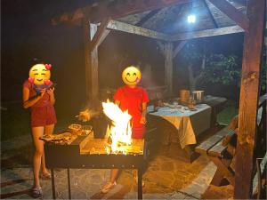科松的住宿－Гостьовий Будинок Косонь，两个人站在烤炉前,火烧