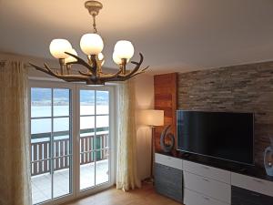 sala de estar con TV y lámpara de araña en Ferienwohnung Mayrhofer, en Innerschwand