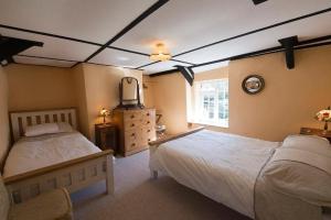 sypialnia z dwoma łóżkami i telewizorem w obiekcie Bridge Cottage Withypool w mieście Withypool