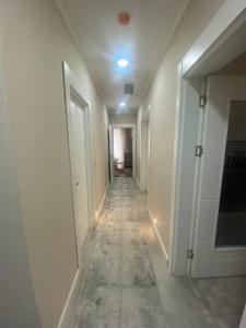 a hallway with white walls and a long hallway with white doors at ЖК Стамбул сити in Yakkasaray