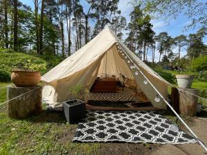 a canvas tent with a bed in a field at Glamping Zelt in Templin