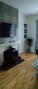 uma sala de estar com uma televisão de ecrã plano na parede em Moor House em Kilmuckridge