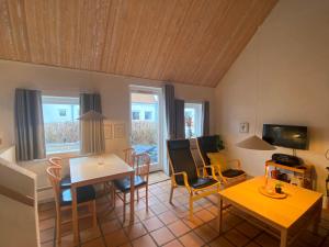 a living room with a table and chairs and a television at Holiday home in resort in Skagen with public pool in Skagen