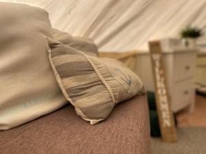 a pillow sitting on top of a couch at Glamping Zelt in Templin +26 photos