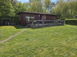 a small cabin in a yard with a grass field at Bospark Lunsbergen - LB 76 in Borger