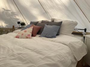 a white bed with pillows in a tent at Glamping Zelt in Templin