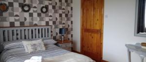a bedroom with a bed and a checkerboard wall at Moor House in Kilmuckridge