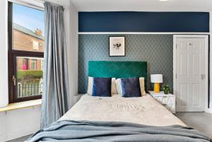 a bedroom with a large bed with a green headboard at Beautiful Gem of Chester - Sleeps 8 - Garden in Chester