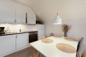 SønderbyにあるCozy apartment in Rømø with access to public poolの白いキッチン(テーブル、椅子付) +2枚の写真