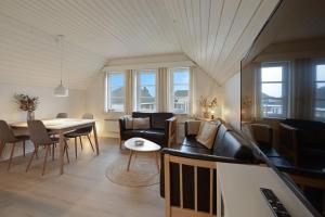 SønderbyにあるCozy apartment in Rømø with access to public poolのソファとテーブルと椅子のあるリビングルーム