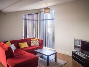 a living room with a red couch and a coffee table at Carraroe Apartment in Carraroe