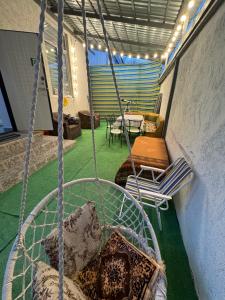 a swing in a room with a table and chairs at Abay Hostel in Almaty