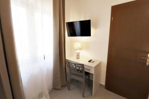 Pokój z biurkiem i telewizorem na ścianie w obiekcie La Pietra Village Rooms w mieście Ruffano