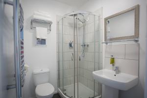 uma casa de banho com um chuveiro, um WC e um lavatório. em Allseasons Hotel em Lowestoft