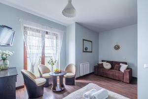 Flatbook - Sztutowo Lazurowy Dwór في شتوتوفو: غرفة معيشة مع أريكة وطاولة وكراسي