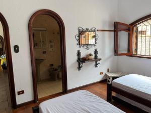 Cette chambre comprend 2 lits, un miroir et une salle de bains. dans l'établissement Casa 30 m da praia,condomínio Tenório, à Ubatuba