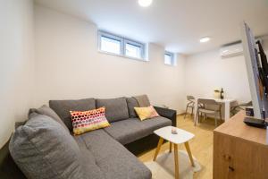 a living room with a gray couch and a table at Apartment Zvoncac in Split