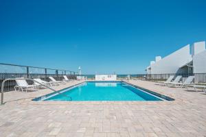 a swimming pool on the roof of a building at Ground floor beachfront with steps to the beach and pool & beach access in New Smyrna Beach