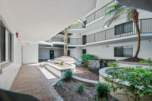 an open courtyard with palm trees and a building at Ground floor beachfront with steps to the beach and pool & beach access in New Smyrna Beach