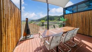 a wooden table and chairs on a deck with a view at Majoong Pool Villa Pension 