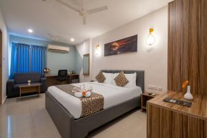 a hotel room with a bed and a desk at Hotel Seasons Inn in Nellore