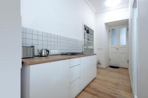 a kitchen with white cabinets and a wooden floor at HB apartments Tabukashvili in Tbilisi City