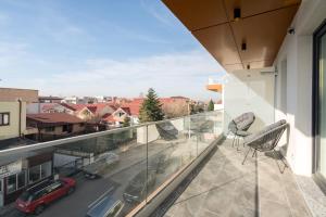balkon z krzesłami i samochód na ulicy w obiekcie Pastel Green I 1 BR apt with terrace w mieście Voluntari