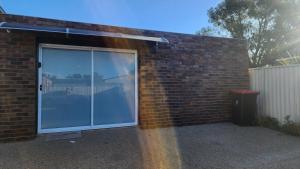 a large sliding glass door in a brick building at Shepparton Central Guest Suite in Shepparton