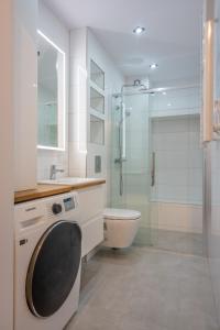 a bathroom with a toilet and a glass shower at Apartament Sztutowo by Ski and Sea in Sztutowo