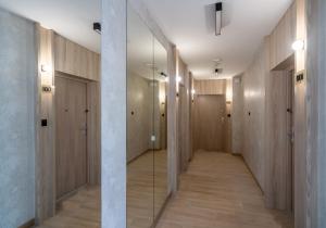 a hallway with wooden doors and a glass corridor at Apartament Sztutowo by Ski and Sea in Sztutowo