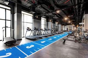 a gym with people exercising on tread machines at Hyatt Centric Jumeirah - King Room Skyline - UAE in Dubai