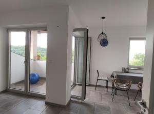 Zimmer mit Glasschiebetüren, einem Tisch und einem Stuhl in der Unterkunft Sobe Lavanda in Kojsko