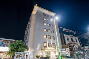 a tall white building with a sign on it at Hotel Seasons Inn in Nellore