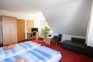 ein Hotelzimmer mit einem Bett und einem Sofa in der Unterkunft Pension Krone in Schwäbisch Gmünd