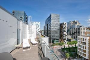 a balcony with chairs and a view of a city at Clarion Hotel Oslo in Oslo