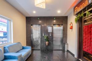 a waiting room with a blue couch and a elevator at Hotel Seasons Inn in Nellore