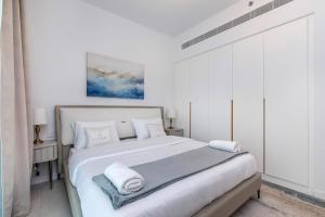 ein weißes Schlafzimmer mit einem großen Bett mit Handtüchern darauf in der Unterkunft Luxury apartments at La Vie in Dubai + 32 Fotos