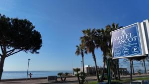 un panneau pour un lit de paille avec des palmiers et la plage dans l'établissement MOTEL ASCOT - Hotel & Appartements, à Cagnes-sur-Mer