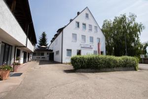 a white building sitting next to a street at Pension Krone in Schwäbisch Gmünd