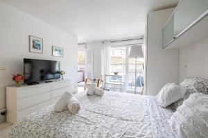 Habitación blanca con cama y TV en Charming Studio with balcony & Clim -Heart of Nice, en Niza