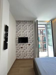 a bedroom with a bed and a tv on a wall at Binario 14 Piazza Garibaldi in Naples