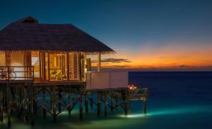 una casa en un muelle con el océano al atardecer en Six Senses Laamu, en Laamu Atoll