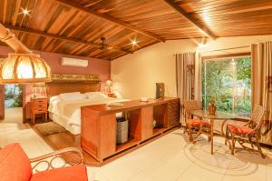 a bedroom with a bed and a table and chairs at Hotel Ponta do Madeiro in Pipa