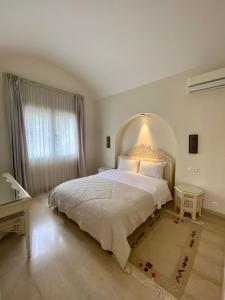馬赫迪耶的住宿－Dar Set El Kol, Résidence de charme à Mahdia，卧室设有一张白色大床和一扇窗户。